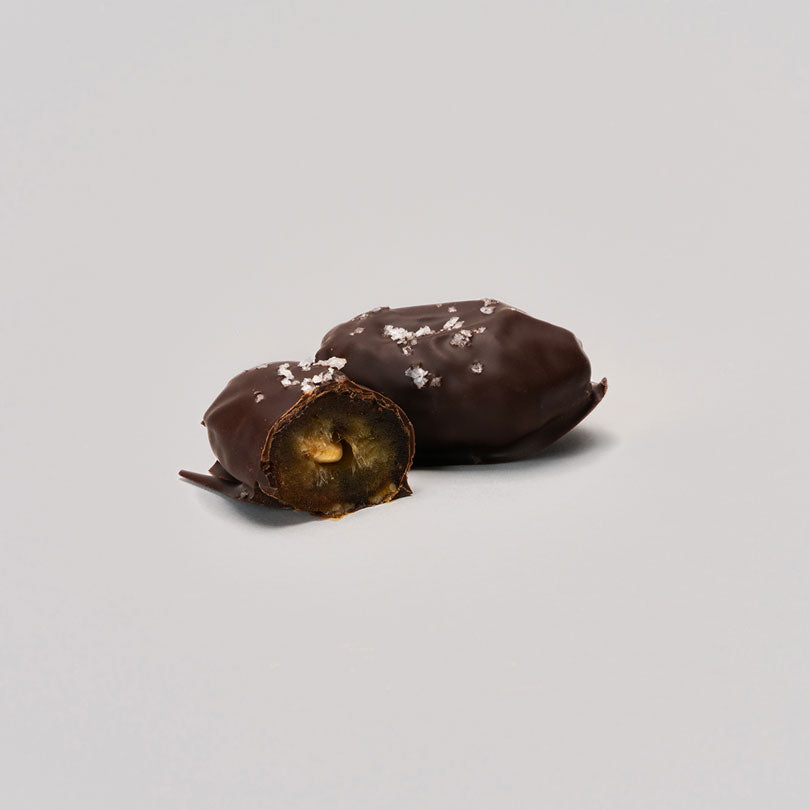 Un paquete de 12 dátiles Medjool rellenos de frutos secos y cubiertos con 100% cacao